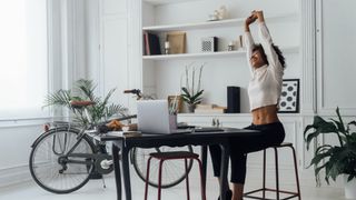 Woman stretching while working at desk
