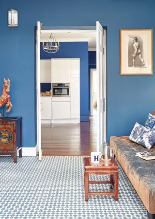 blue orangery with original tiles and sofa with kitchen with wooden floor