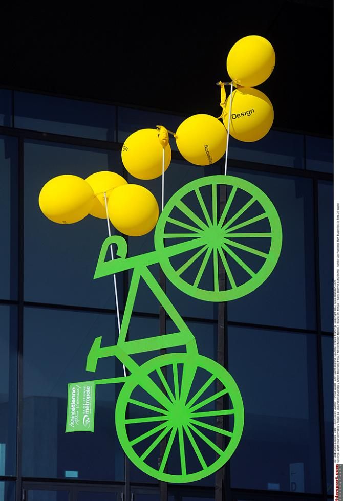 An artistic display of yellow balloons tied to a green bike