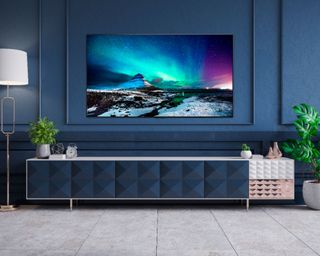 LG G1 TV in dark blue living room mounted above navy, white and copper TV stand