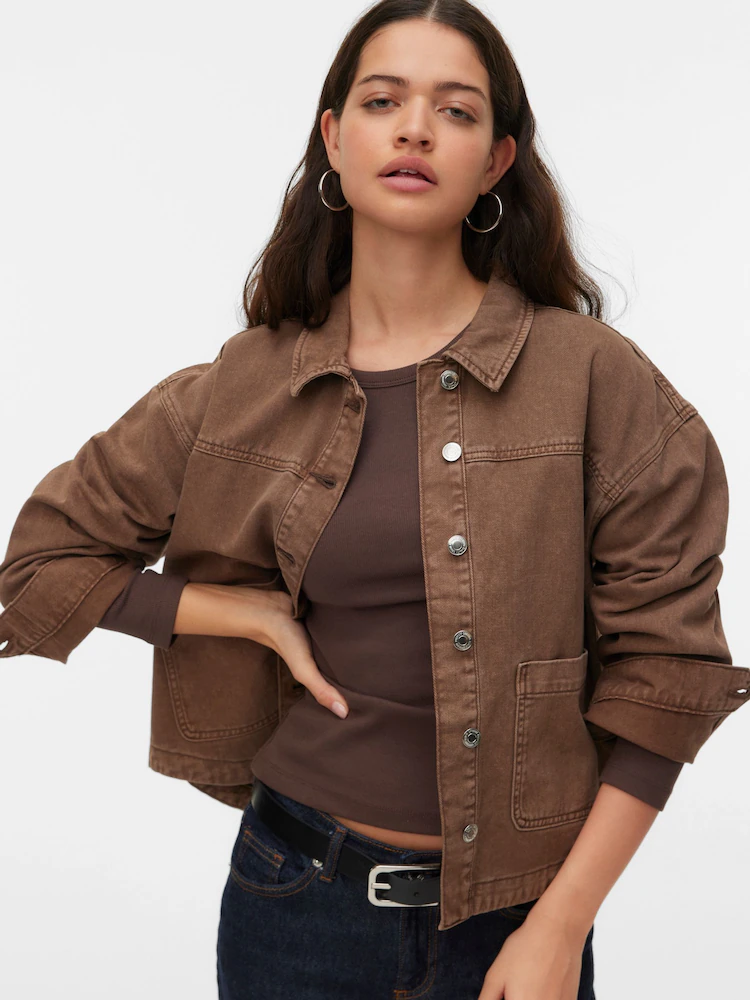 A model wears a brown denim jacket from Next.