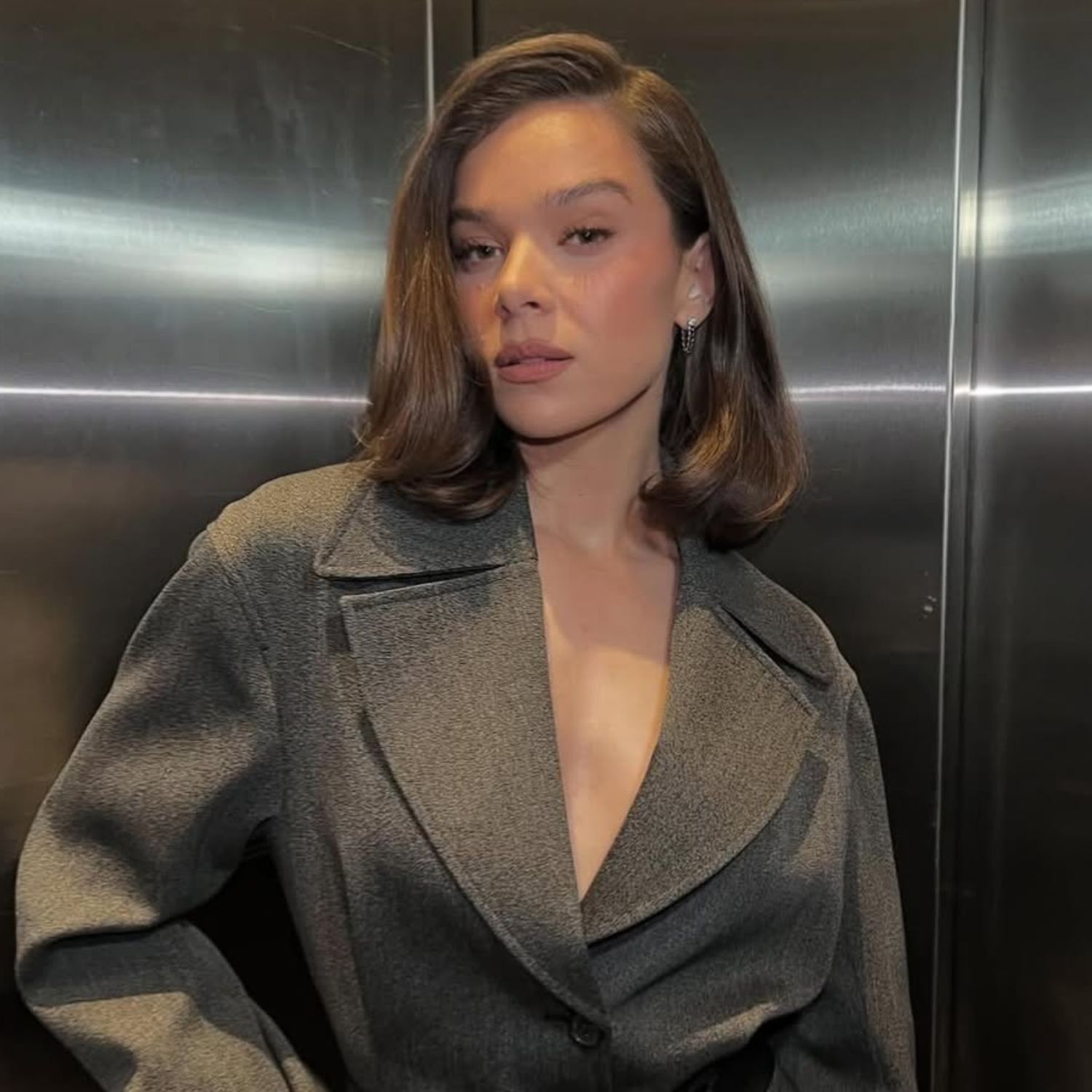 @haileesteinfeld wearing hair in a long Monaco Bob with grey coat