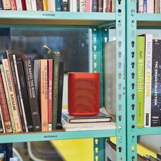 book shelves with book and red speaker