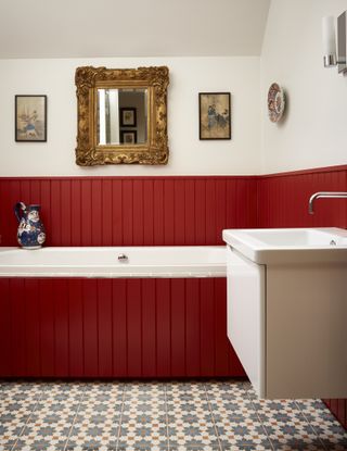 bathroom with red painted shiplap, tiled floor, white walls, wall mounted white vanity, artwork