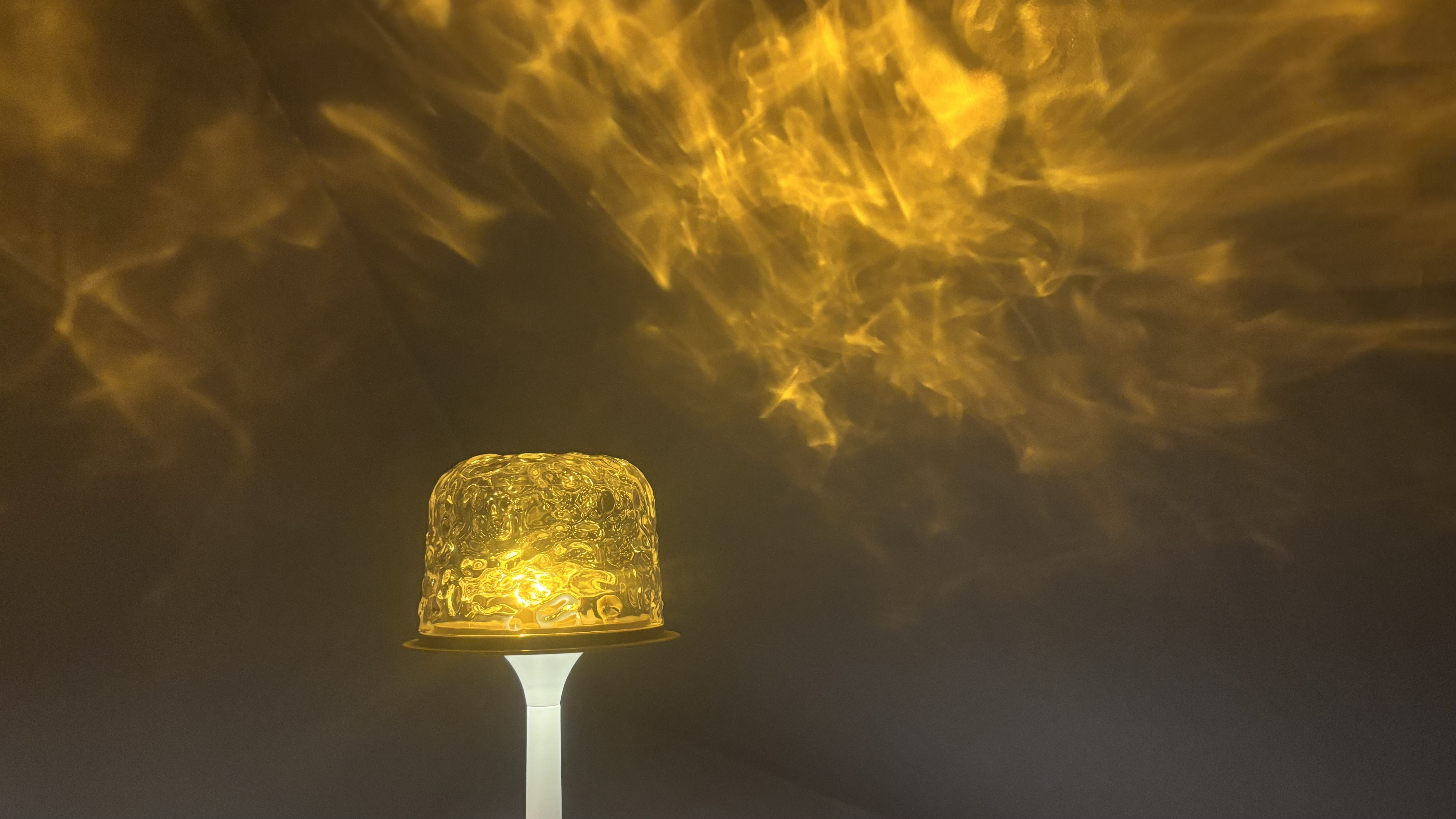 The Auria Glow Lamp creating atmospheric warm-amber lighting in a dimly-lit bathroom.