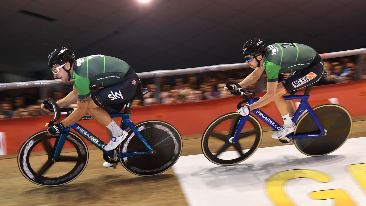 Two riders on track bikes with tri-spoke and five-spoke wheels