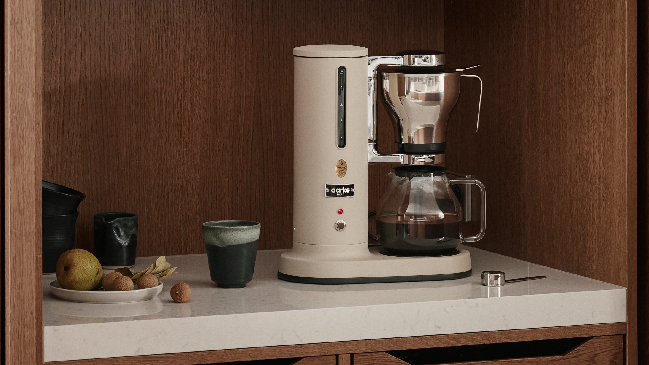 Aarke Coffee Maker in Sand on kitchen counter
