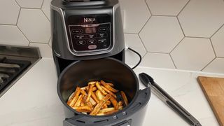 The Ninja Air Fryer Max AF160 with fries in the basket that have just been cooked in the air fryer