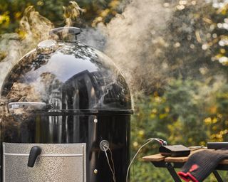 An outdoor grill with a meat thermometer hooked up