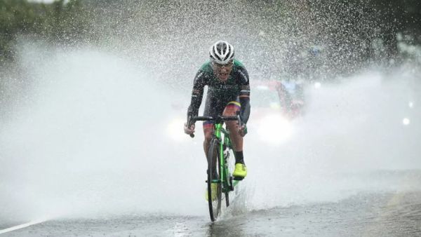 A man rides through a large puddle on a road bike on the best winter road bike tyres 