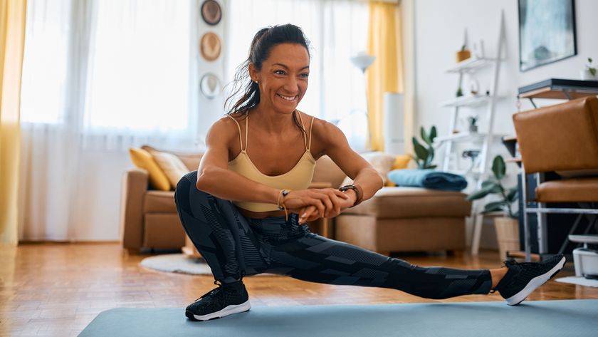 Woman performing Cossack squat at home