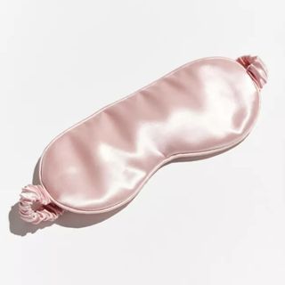 A pink satin-style sleep mask on a white background. 