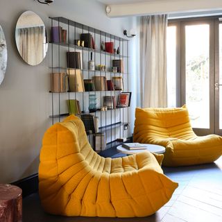 Living room with two retro yellow chairs and open storage bookcase