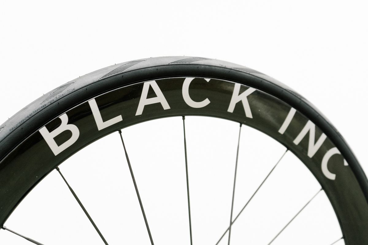 An aero road wheel stands against a white wall