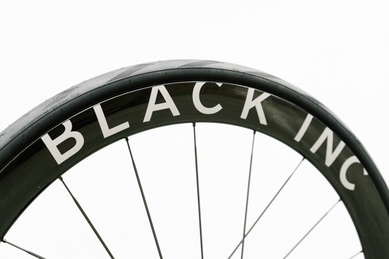 An aero road wheel stands against a white wall