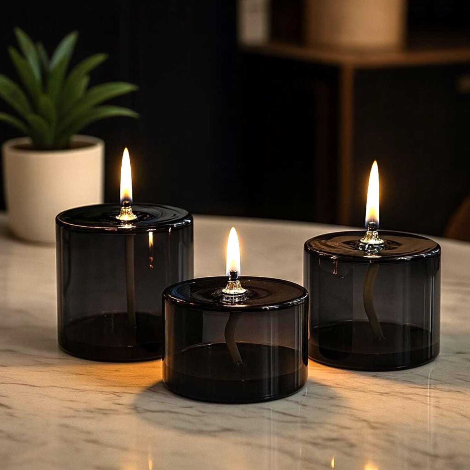 A set of three black glass oil lamps