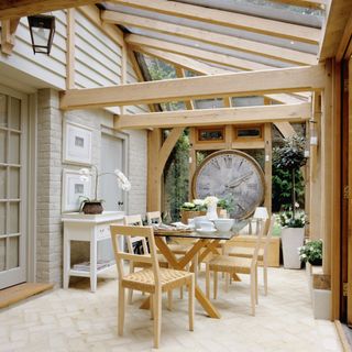 wooden conservatory dining room with painted exterior brick wall