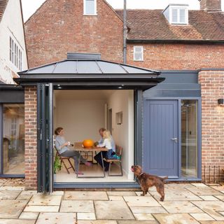 small modern extension to listed building with grey bifold doors