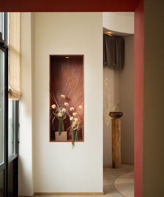 A white room with pink accents and vases of flowers