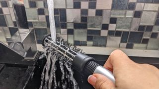 Washing brush under tap