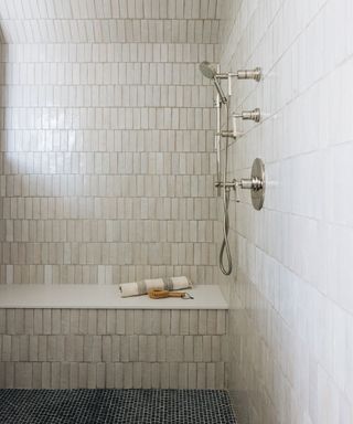 simple bathroom with neutral tiles and shower seat