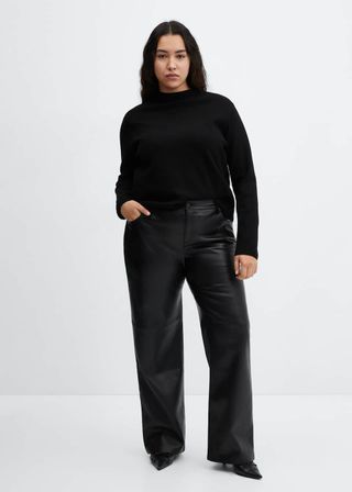 model wears black turtleneck and wide leg leather pants 
