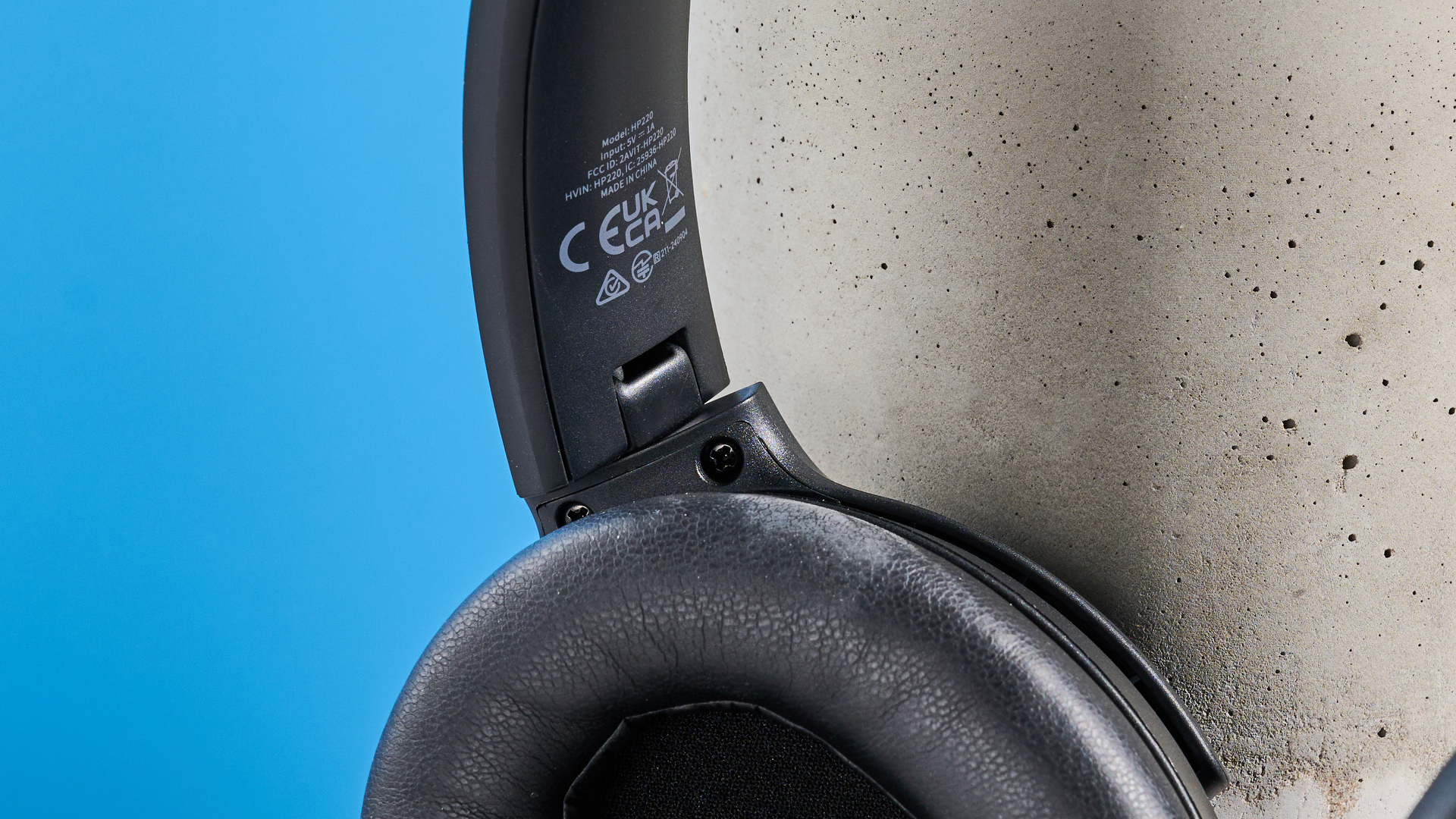 the earfun tune pro headphones, in black, with soft pleather cups, and gray cups, photographed against a blue background