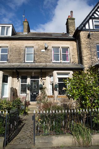 An external shot of the front of the Victorian house, with black painted front door