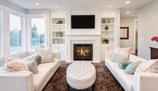 Elegant living room with sofas placed either side of a roaring fire