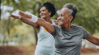 two older women holding yoga pose