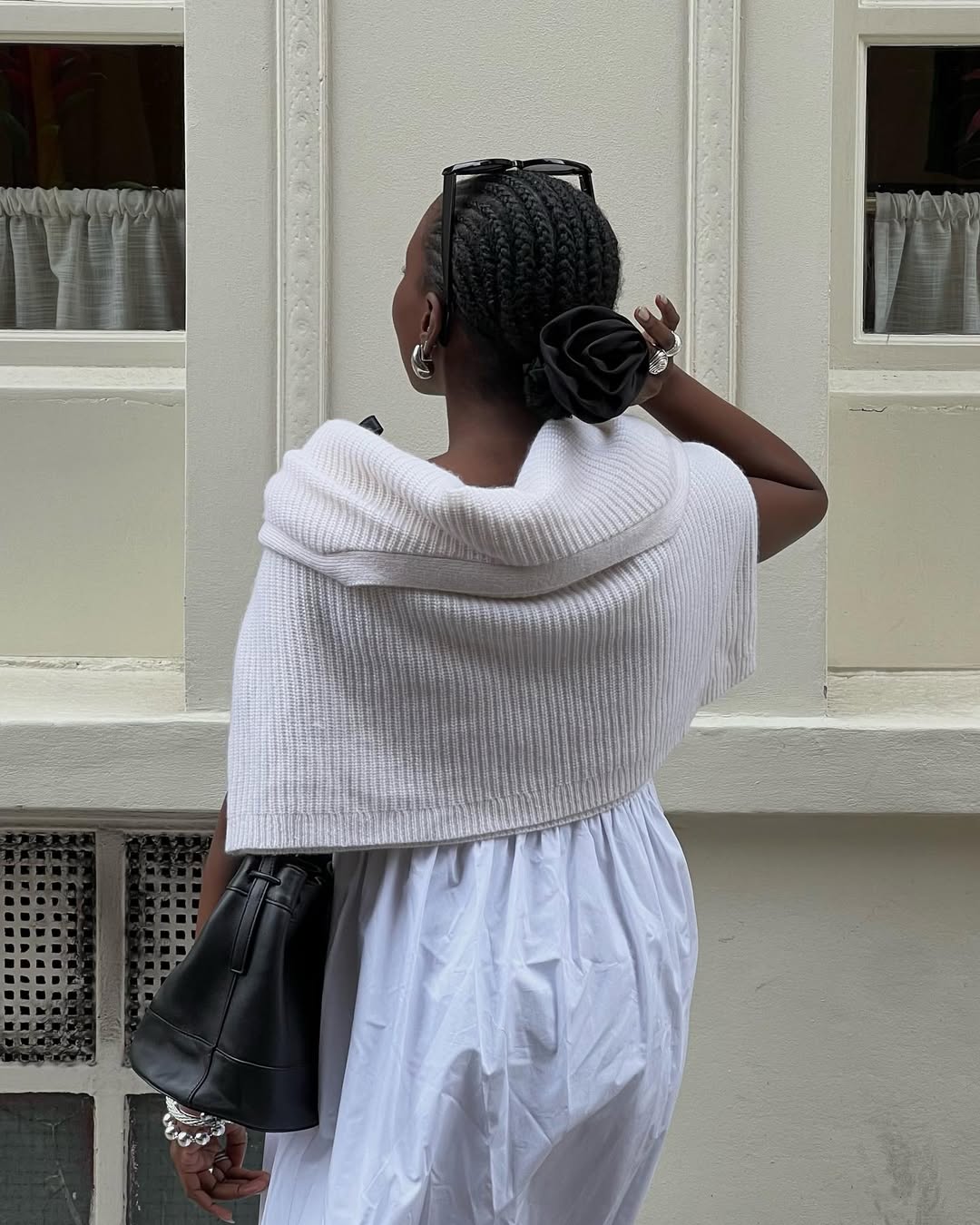Danielle Jinadu wears straight back braids in a bun with a rosette hair accessory