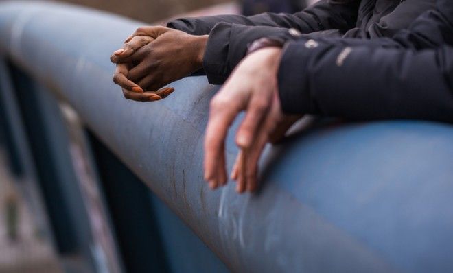 Hands folded on railing