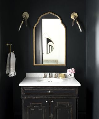 Black bathroom with gold mirrors