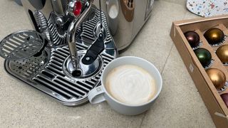 Nespresso Vertuo Creatista next to a freshly-amade cappucino