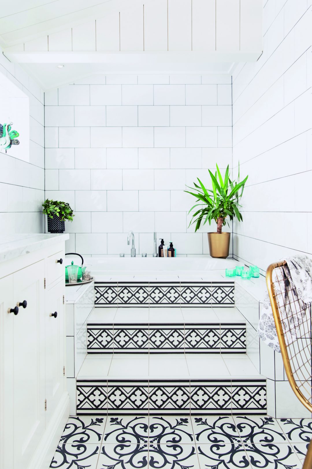 small bathroom with steps and patterned black and white tiles