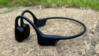 The Suunto Sonic headphones photographed on a sandstone paving stone.