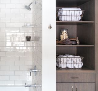 Open shelving in a bathroom with rolled towels and other decor