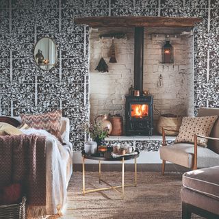 A living room with a fireplace and a floral wallpaper