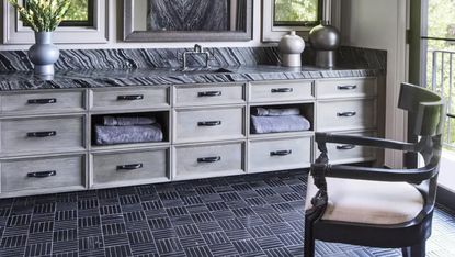 a bathroom with a black floor and black marble countertop