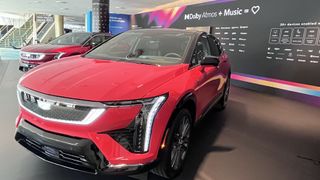 Red Cadillac OPTIQ with Dolby Atmos Music sign in background