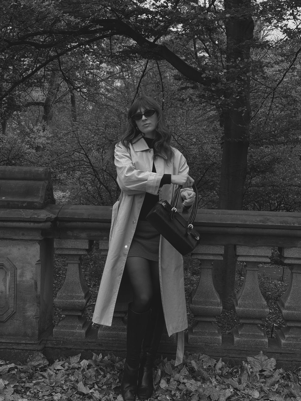 Kathryn Zahorak in black and white wearing trench coat, sunglasses, and knee-high boots