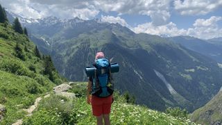 A woman hiking to Cabane de Louvie with a yoga mats on her backpack