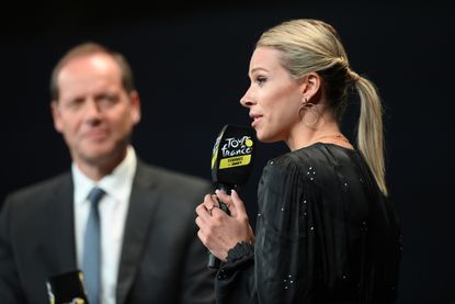 Marion Rousse speaking into a Tour de France branded microphone