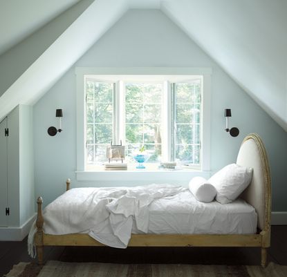 pale blue bedroom with bed placed in alcove window 