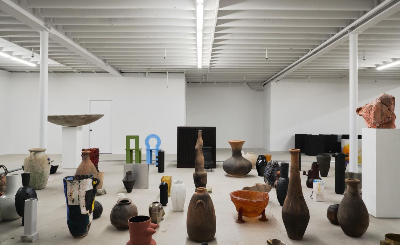 Different sized handcrafted vessels on the floor in a studio.