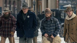 From left to right, a cowboy, Harrison Ford as Jacob walking with his hands in his pockets, Darren Mann as Jack walking with his hands on his belt and another cowboy walking in 1923.