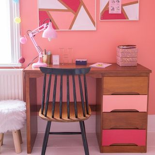 childrens room with pink wall wooden table and chair