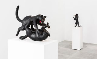 Bronze cats in different poses and with illuminated eyes