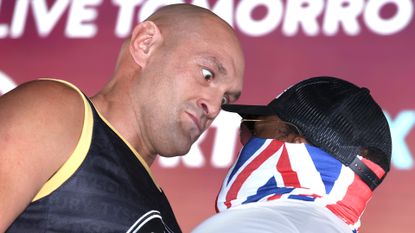 Tyson Fury flexing at weigh in with Derek Chisora before their world heavyweight boxing fight
