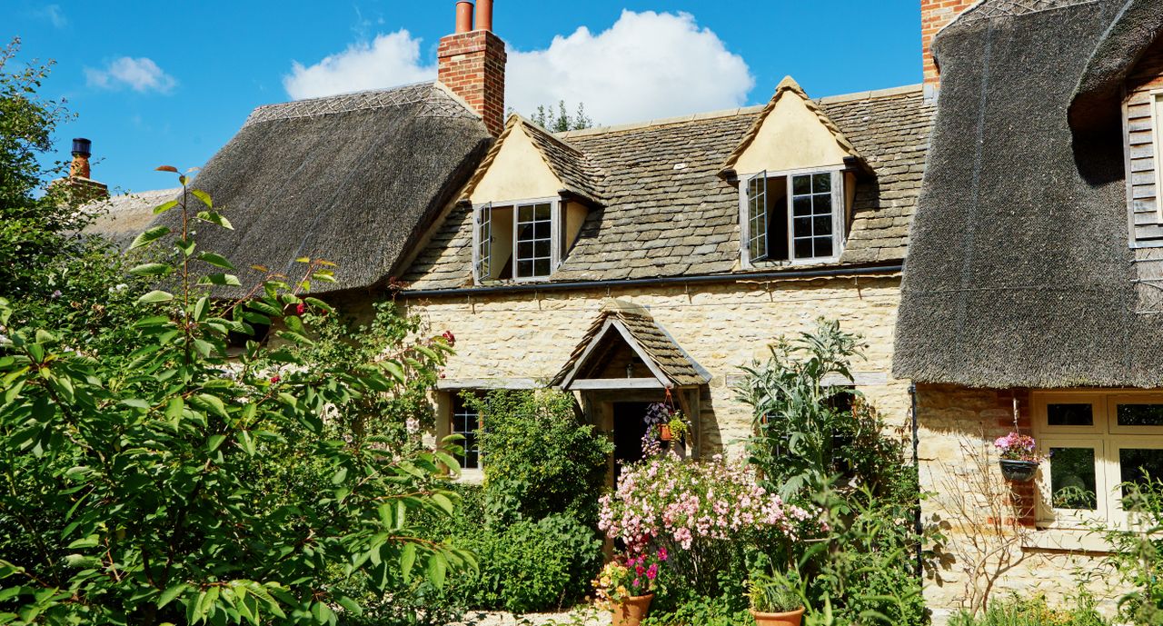 part-thatched cottage with cottage garden and gabled windows